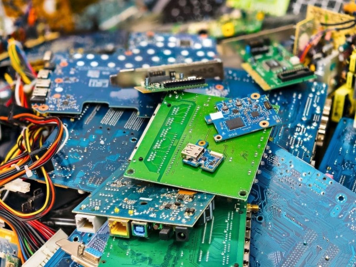 Nowy telefon obok starych baterii i obudów z recyklingu w linii produkcyjnej
