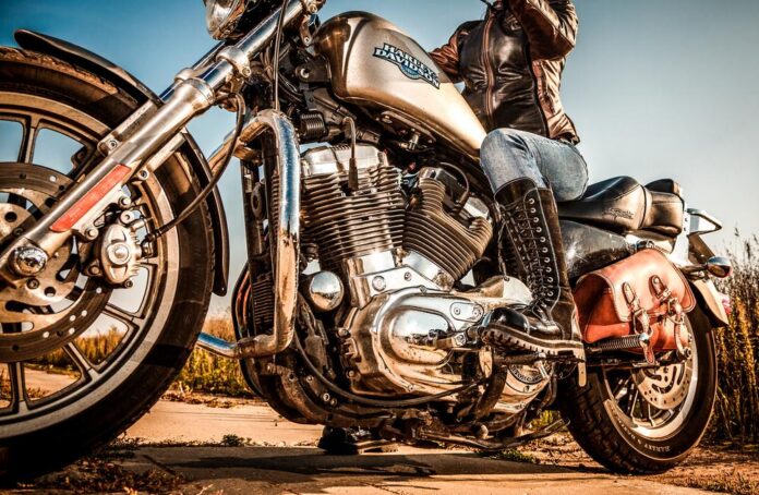 Chromowany motocykl stoi przed garażem w świetle dziennym