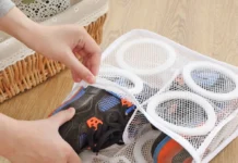 Pranie butów w pralce – jak przygotować obuwie i po co używać siatki? Para białych butów sportowych w przezroczystej siatce obok otwartej pralki