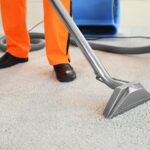Dry cleaner’s employee removing dirt from carpet in flat
