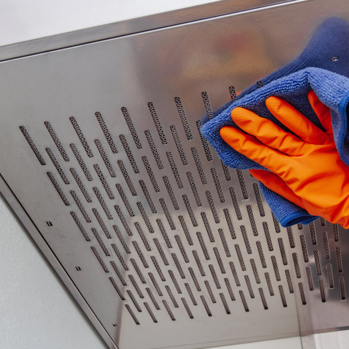 czyszczenie lamp w okapie kobieta przecierająca lampy okapu miękką ściereczką